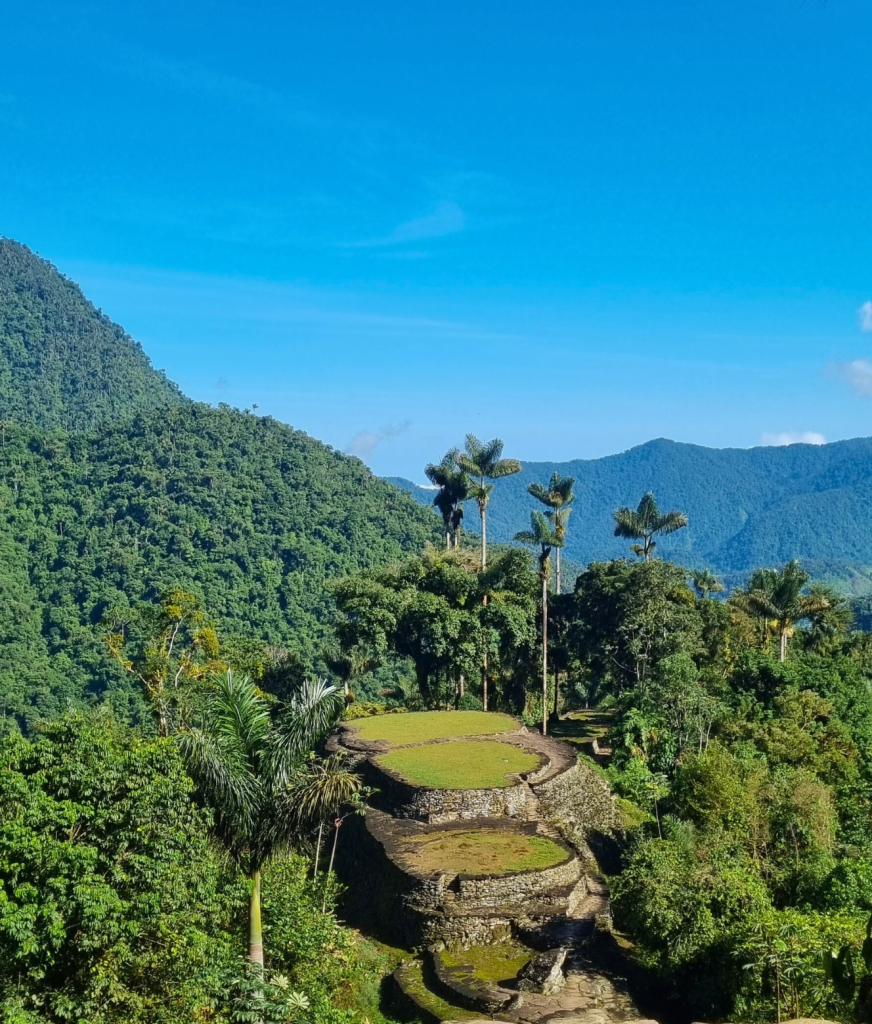 Iconic view of the Lost City terraces nestled in the mountains, with layered stone platforms surrounded by jungle-covered hills.