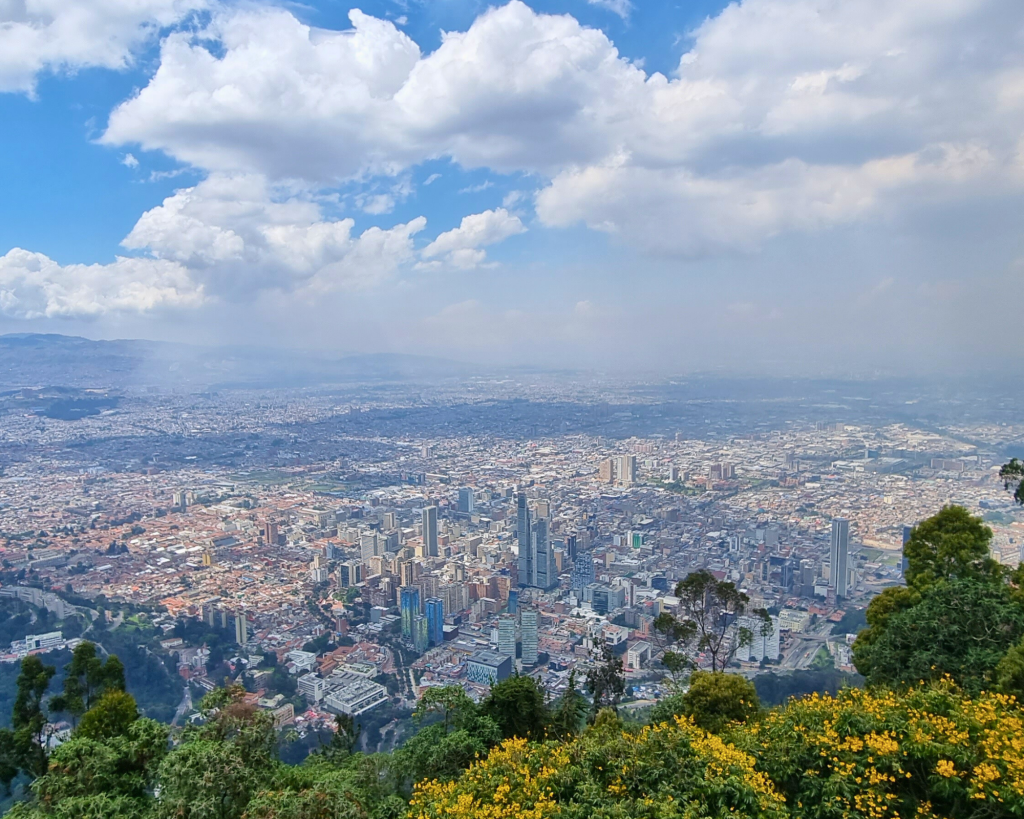 Panoramic view of Bogotá from the Monserrate Mountain, with the city skyline framed under a clear blue sky.