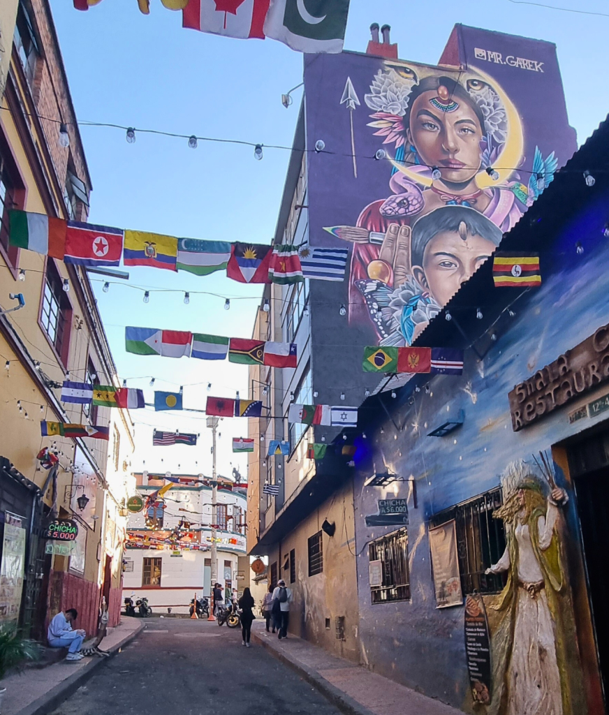 Colorful street art in the La Candelaria district of Bogotá, blending traditional and modern elements of Colombian culture on a brick wall.
